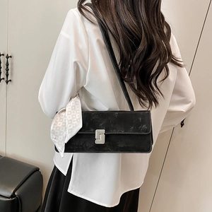 Sac baguette noir avec boucle en diamant et foulard en soie attaché à l'anse