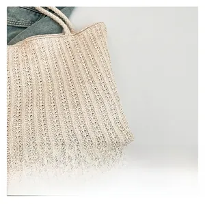 Close-up of straw woven tote bag featuring braided handles and natural texture