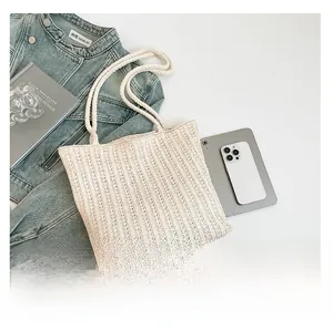 Close-up of cream woven tote bag with intricate hollow texture and cotton rope handles