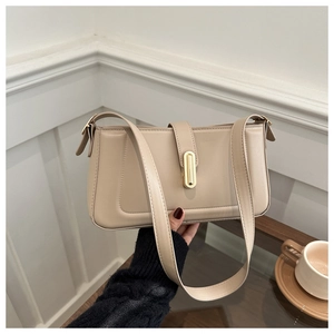 Detailed view of beige faux leather handbag with elegant gold oval metal clasp