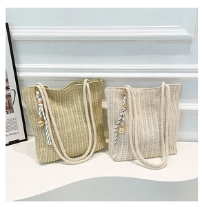 Detail of woven straw tote bags with cotton rope handles and stylish silk ribbon accents