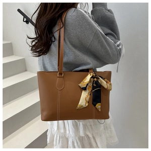 Brown vintage tote bag with silk scarf detail shown on shoulder for daily commute
