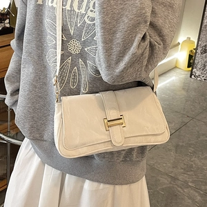 Chic beige baguette underarm bag with gold H-buckle and adjustable shoulder strap