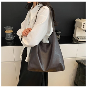 Close-up of a large coffee brown tote bag showing its premium leather texture and stitching