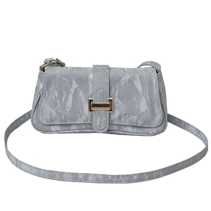 Minimalist grey baguette shoulder bag with crinkled texture and golden buckle closure