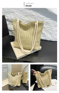 Detailed macro view of khaki woven straw tote bag featuring thick white cotton rope handles