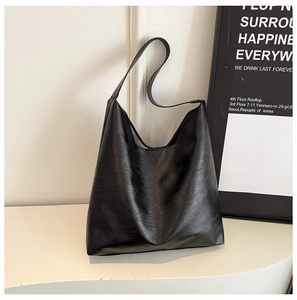 Detail of minimalist black leather tote bag with smooth texture and soft hobo structure