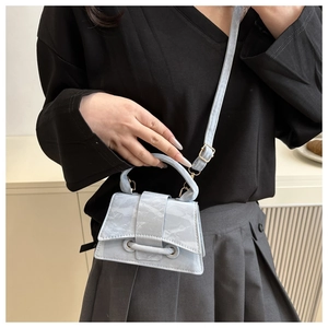 Detail of light blue mini trapezoid handbag with marble texture and curved handle