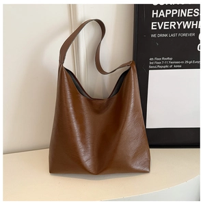 Detailed view of vintage brown PU leather tote with wide shoulder strap and textured finish