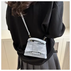 Detail of light blue hourglass mini bag featuring textured finish and unique handle