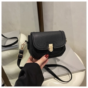 Détail du sac à bandoulière en cuir noir grainé avec fermoir rotatif doré brillant