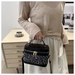 Sac à main tendance à motif léopard tenu par un mannequin dans un décor d'intérieur