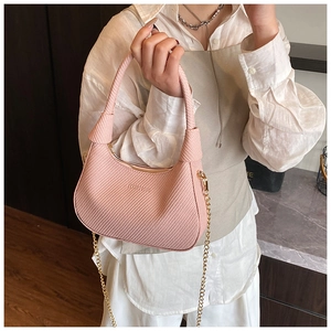 Detailaufnahme der rosa sichelförmigen Handtasche mit Webstruktur und Goldkette