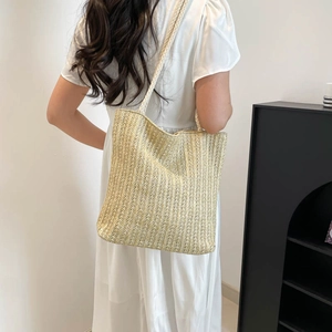 Beige woven straw tote bag with vertical textured patterns for beach and summer travel
