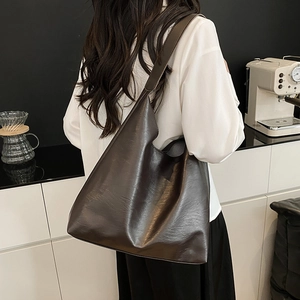 Minimalist large dark brown leather tote bag for women showing a stylish shoulder carry view