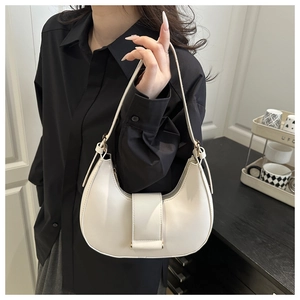 Detailed close-up of a white hobo bag with smooth leather finish and metallic magnetic clasp