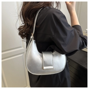 Silver crescent moon shoulder bag in metallic leather shown on model for sizing