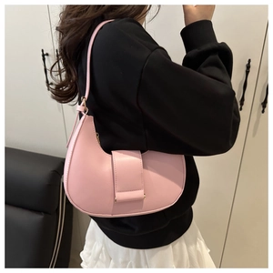 Model view of pale pink leather hobo shoulder bag with sleek gold hardware and slim strap