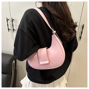 Pink crescent hobo bag with leather buckle detail worn over the shoulder on a model