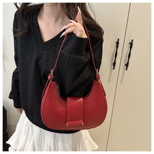 Close-up of red hobo bag with smooth faux leather finish and metallic buckle detail