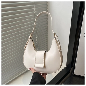 Detail of cream hobo bag showing smooth leather texture and golden buckle on the side