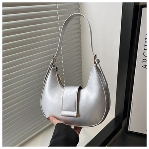 Detail of silver crescent armpit bag with metallic leather and gold hardware buckle