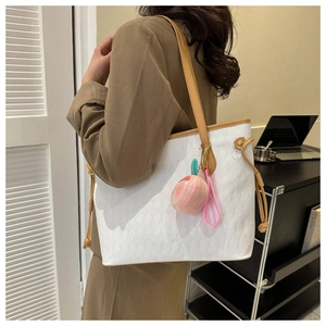 Quilted tote bag with peach charm and drawstring details shown on female model