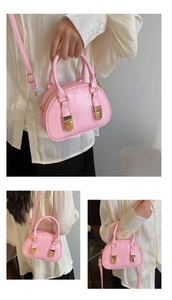 Detail of pink Boston shell bag showing golden hardware and adjustable crossbody strap