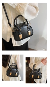 Detail view of black Boston shell bag with golden buckles and adjustable shoulder strap