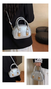 Detail of silver metallic mini Boston bag with gold hardware and fine stitching accents