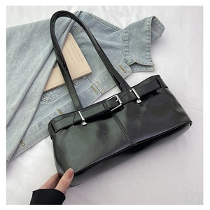 Detail of black glossy PU leather shoulder bag with silver buckle and adjustable strap