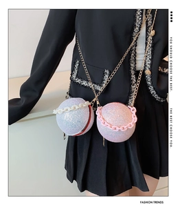 Detail of glitter spherical evening bag with metallic chain and decorative strap