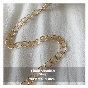 Detail of a premium golden alloy chain shoulder strap with dense oval links