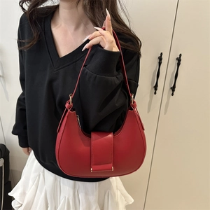 Red crescent shoulder bag in smooth faux leather featuring adjustable strap and gold hardware