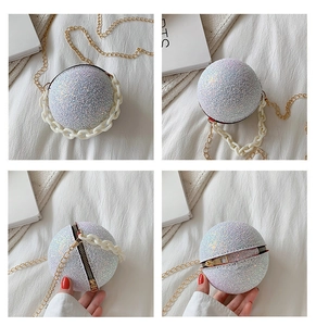 Macro shot of silver spherical clutch bag with glittering finish and dual chain straps