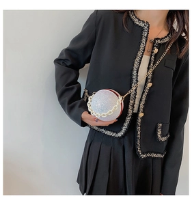 Close-up of a glittering spherical clutch bag with chunky white and gold metal chains