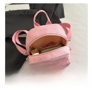 Interior view showing corduroy backpack capacity with lipstick and wallet storage