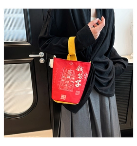 Detail of red Year of the Snake lucky money canvas bag with yellow straps and gold patterns