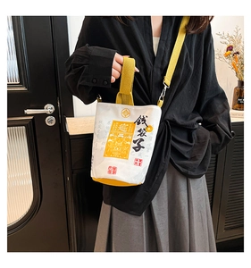 Lifestyle shot of an off-white canvas drawstring bag with money pouch calligraphy and yellow strap