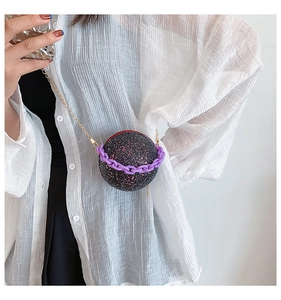 Detailed view of spherical sequined bag with purple chain and gold metal strap
