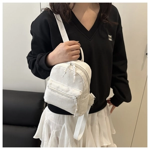 Détail du mini sac à dos en velours côtelé blanc avec poches zippées et bretelles