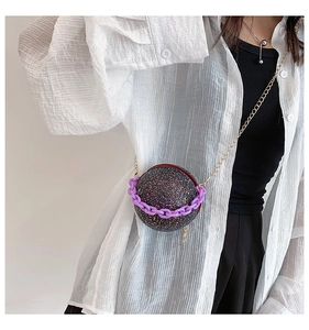 Detailed view of spherical sequin crossbody bag with gold chain and purple plastic handle