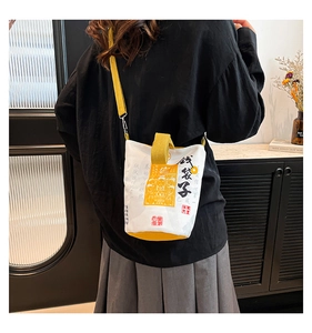 Detail view of canvas bucket bag featuring lucky calligraphy and adjustable yellow straps