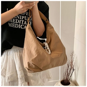 Dettaglio di una grande borsa tote marrone in nylon con corda intrecciata e tracolla larga