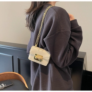 Detailed back view of a mini cream leather crossbody bag with a golden chain strap