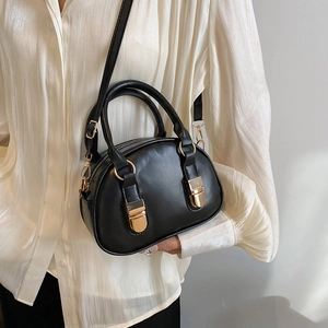 Chic black shell-shaped leather handbag with gold hardware and adjustable shoulder strap