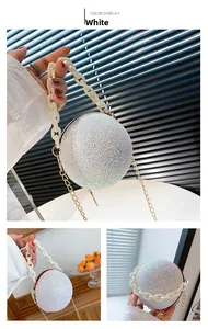 Detail of white spherical evening bag with silver glitter surface and acrylic handle