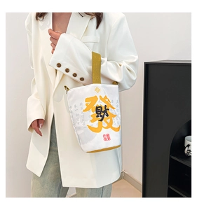Detail of canvas bucket bag with yellow 'Fortune' calligraphy and ivory fabric texture