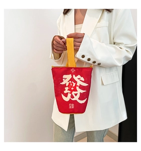 Detail of red Year of the Snake canvas tote bag featuring white calligraphy and yellow handle