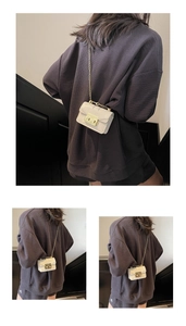 Detailed back view of model wearing a mini off-white crossbody bag with gold chain strap